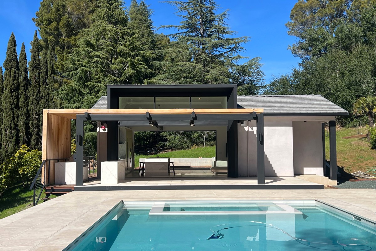 Luxury home remodeling in Menlo Park showing a structural open-concept kitchen and living room addition with exposed beams and sliding glass doors.